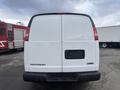 Rear view of a 2022 GMC Savana van featuring a white exterior with the Savana and GMC logos displayed on the back doors without any additional markings or features