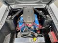 Engine compartment of a 1968 Ford Mustang Two Door Convertible featuring a blue engine block with red wiring and various mechanical components