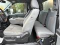 Interior view of a 2015 Ford F-450 showing gray fabric seats with a spacious cabin layout and a center console