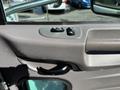A close-up of the interior door handle and window controls of a 2020 Peterbilt 330 with a textured finish