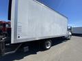 A 2014 International TerraStar truck with a large white cargo box and black chassis parked on a paved surface