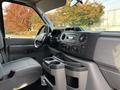 Interior view of a 2013 Ford E-350 Super Duty showing the dashboard steering wheel and center console with controls and cup holders