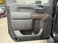 The interior door panel of a 2022 GMC Sierra 3500HD featuring a wood trim accent and storage compartment
