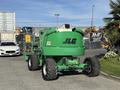A green 2015 JLG 450AJ aerial lift with large wheels and a telescoping boom seen from the rear