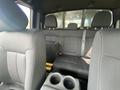 Interior view of a 2014 Ford F-150 showing the rear seating area with black fabric seats and a central cup holder console
