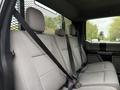 The interior of a 2020 Ford F-550 featuring a grey fabric bench seat with seatbelts
