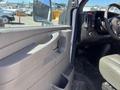 Interior view of a 2013 Chevrolet Express showing the driver's side door panel and dashboard with controls and a steering wheel
