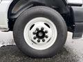 The image shows a close-up of a white wheel and tire from a 2024 Ford E-450 with a detailed tread pattern and five lug nuts visible on the rim