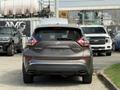 A 2016 Nissan Murano parked facing forward with a brown exterior and distinctive taillights