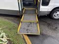 A 2018 Chevrolet Express with a deployed wheelchair ramp extending outward from the vehicle's side door