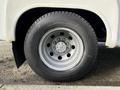A close-up of the wheel and tire of a 2002 Ford Econoline showing the metal rim and tread pattern of the tire