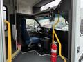 Interior view of a 2013 Chevrolet Express showing the driver's seat steering wheel dashboard and a fire extinguisher mounted on the side