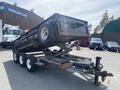 2009 Load 16 foot Dump Trailer with a raised bed and a hitch for towing featuring three axles and a metal frame