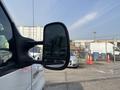 A 2008 Ford Econoline van with a side mirror visible in the foreground
