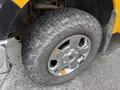 Close-up of a 2014 Ford F-150 tire with a rugged tread pattern mounted on a shiny chrome wheel