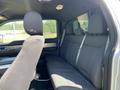 Interior view of a 2014 Ford F-150 showcasing the rear seating area with black fabric upholstery and seatbelts