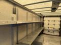 2012 Ford Econoline with metallic shelving inside a cargo area the shelves are mounted along the walls and are empty with a flat floor
