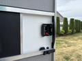 Close-up of a 2020 Freightliner MT45 cargo door latch mechanism with a red release handle and metal mounting plate