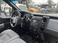 Interior view of a 2013 Ford F-150 featuring a steering wheel dashboard and center console with audio controls and climate settings