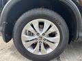 A close-up of a silver alloy wheel of a 2014 Honda CR-V featuring a tire with the brand name Continental and a tread pattern designed for all-season performance