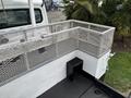 A 2013 Freightliner 114SD truck featuring a metal mesh railing around a flatbed area with a small black step at the corner