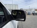A side mirror of a 2018 Chevrolet Silverado 1500 reflecting part of the interior cabin and a blurred outdoor scene
