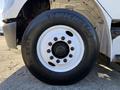 A close-up of a Michelin tire mounted on the wheel of a 2012 Freightliner M2 106 showing the tread pattern and bolt configuration