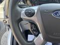 Close-up of a steering wheel from a 2019 Ford Transit 350 featuring control buttons for audio and cruise settings
