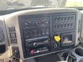The dashboard of a 2014 International 7400 featuring multiple control buttons dials a radio and a screen