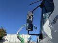 A 2013 International 7500 truck is shown in close-up with its side mirrors reflecting the sky and nearby construction equipment