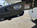 A close-up of a hitch attached to a 2021 Grand Design Recreational ST3478MBS with various labels including a warning and a part identification sticker