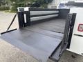 The image shows the open bed of a 2021 RAM 5500 with a flat surface and side toolboxes designed for utility and storage
