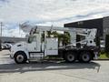 A white 2008 Kenworth T370 truck with a Terex Telelect aerial lift on the back and large wheels parked in a commercial area