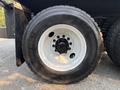Close-up of a black tire mounted on a white rim from a 2016 Freightliner M2 106 truck with a rugged tread pattern