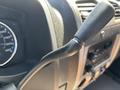 Close-up of a gear shift lever in a 2011 Chevrolet Colorado interior with a speedometer visible in the background