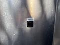 A small black circular inlet labeled INVERTER mounted on a metallic surface
