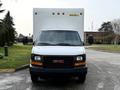 Front view of a white 2015 GMC Savana truck with a large cargo box mounted on the rear and black grille featuring the GMC logo