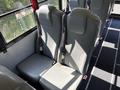 Two gray seats with seatbelts in the interior of a bus designed for passenger transport