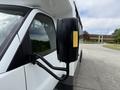 A close-up of the side mirror of a 2020 Chevrolet Express van with a yellow reflective strip and a black casing