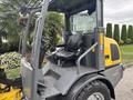 A 2014 Wacker Neuson WL34 compact wheeled loader featuring a black seat and controls for operation