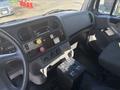 Interior view of a 2022 Freightliner M2 106 showing the dashboard controls including buttons gauges and a black storage box on the floor