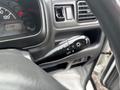 A close-up of the turn signal and headlight control stalk in a 2010 Suzuki Carry with a black finish and illuminated icons for functions