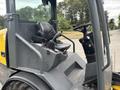 A 2014 Wacker Neuson WL34 compact wheel loader with a black operator seat and steering controls visible in the foreground