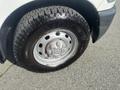 Close-up of a silver wheel with a black Goodyear tire on a 2012 RAM 2500 showcasing a robust tread pattern and chrome lug nut design