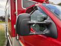 2007 Ford F-550 with a close-up view of its side mirror and a part of the cab in red color with silver detailing