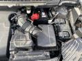 A close-up of a 2017 Ford Edge engine compartment showing the air intake system battery and various electrical components in a slightly dirty condition