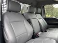 Interior view of a 2023 Ford F-450 Super Duty showing five gray leather seats with seat belts and headrests in a spacious cabin layout