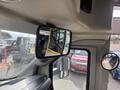 Interior view of a 2018 Chevrolet Express showing the side mirror and rearview mirror with reflections of other vehicles in the background