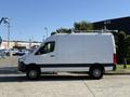A white 2023 Mercedes-Benz Sprinter 2500 van is parked with a high roof and black accents on the side standing on a concrete surface