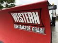 A red snow plow blade with the label Western Contractor Grade attached to a 2012 Dodge Ram 5500 truck